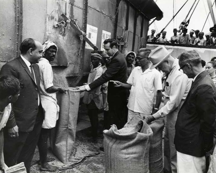 Photograph of Congressmen Poage and Dole watching the unloading of American food grain<br /><br />
